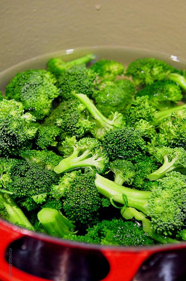 broccoli-boiled-DSC_1447 Ένα μάτσο φρέσκο μπρόκολο κομμένο σε ανθοδέσμες, καλυμμένο με νερό και έτοιμο για μαγείρεμα σε μια μεγάλη κόκκινη κατσαρόλα.