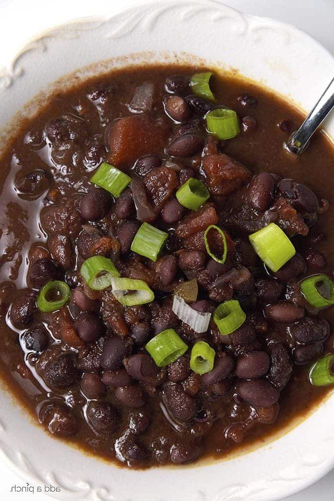 White bowl filled with black bean soup topped with green onion // puvez.com