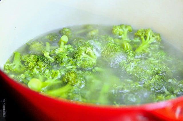 broccoli-boiled-DSC_1454 Κόκκινη κατσαρόλα με μπρόκολο να βράζει σε νερό στην κουζίνα.