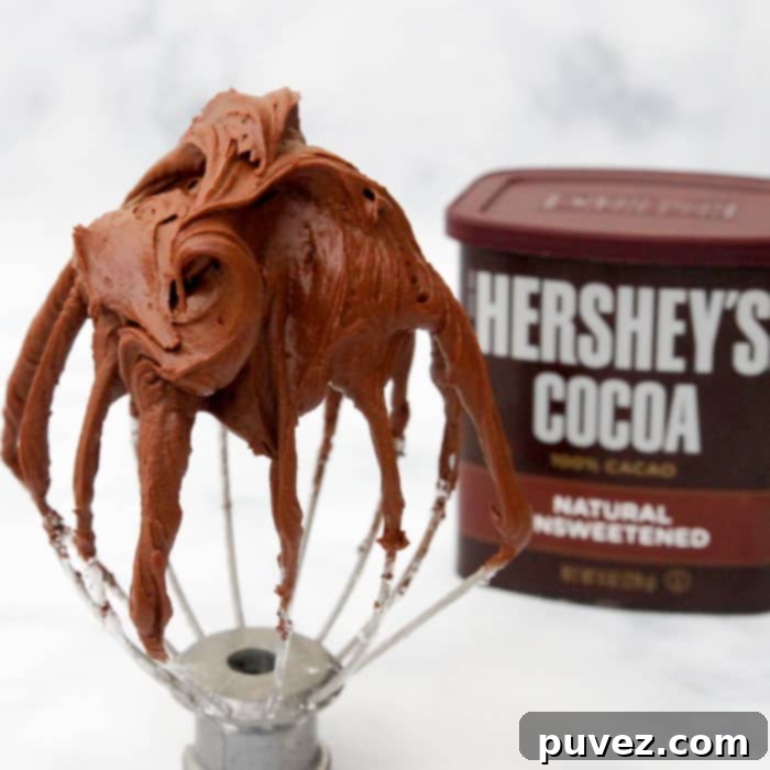 Generously frosted cupcakes with The Best Chocolate Fudge Frosting, highlighting the rich color and smooth texture.
