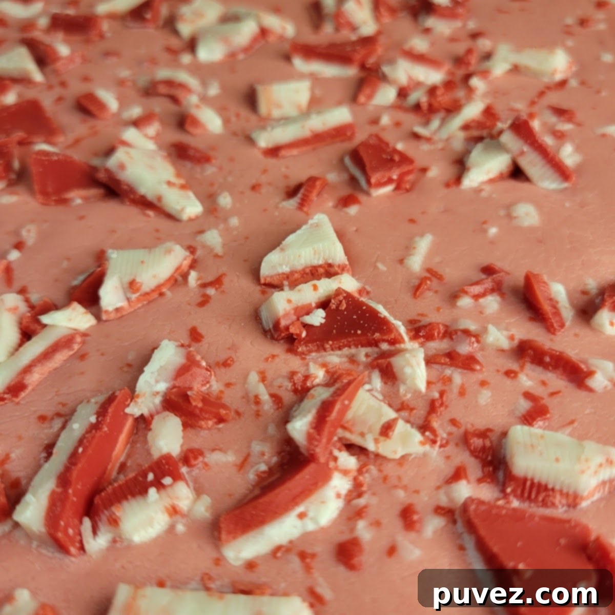 A top-down view of the Andes Peppermint Fudge in a baking pan, garnished with chopped Andes mints before chilling