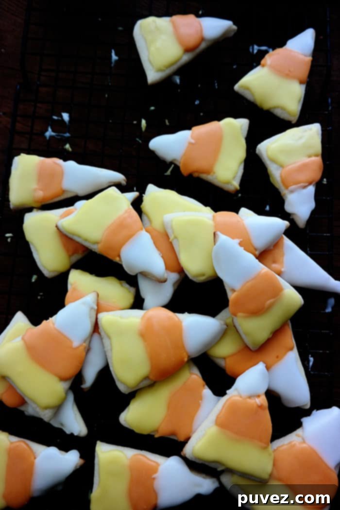 A plate of vibrant Candy Corn Iced Sugar Cookies, ready for Halloween.