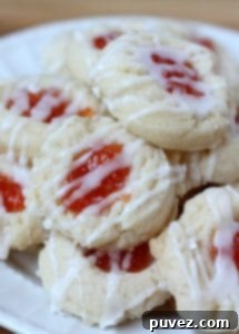 Delicate Almond Shortbread Thumbprint Cookies with a sweet jam filling.