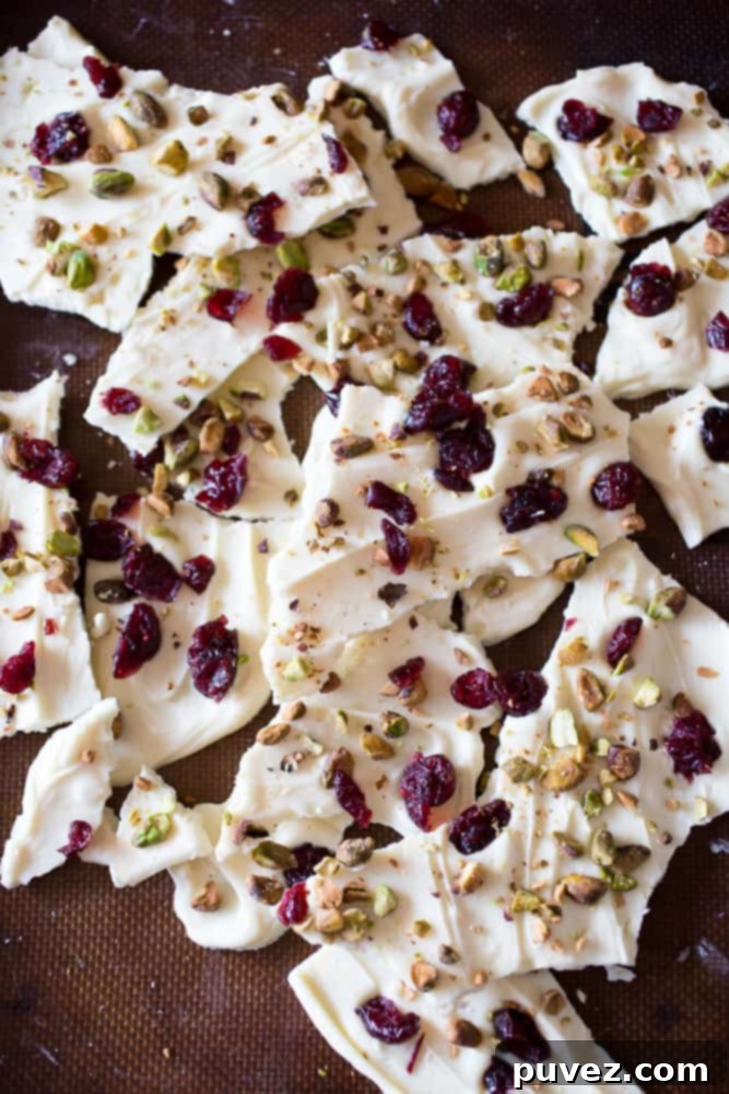 Delicious White Chocolate Cranberry Pistachio Bark decorated with festive red cranberries and green pistachios, perfect for holiday gatherings.