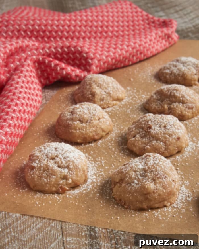 Toffee Pecan Snowdrop Cookies - a close-up showing their powdered sugar coating and rich texture, perfect for holiday gatherings.