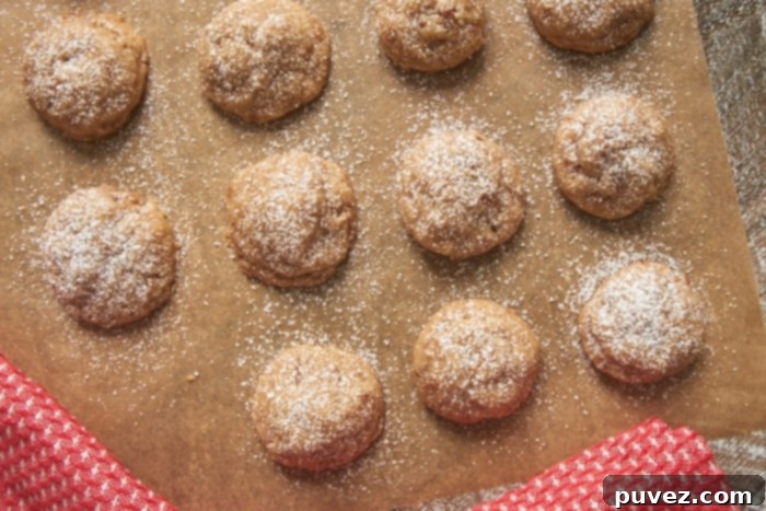 Freshly baked Toffee Pecan Snowdrop Cookies cooling on a wire rack, waiting for their finishing touch of powdered sugar.
