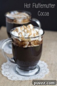 Hot Fluffernutter Cocoa in a mug, topped with whipped cream and mini marshmallows