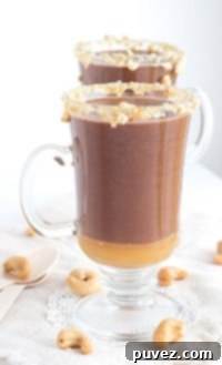 Caramel Cashew Hot Cocoa, garnished with caramel drizzle and chopped cashews