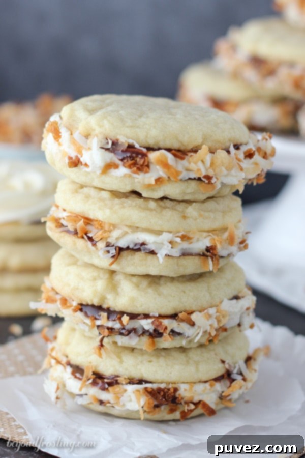 Close-up of a perfectly constructed Samoa Cookie Sandwich showing the layers of cookie, caramel, chocolate, and toasted coconut