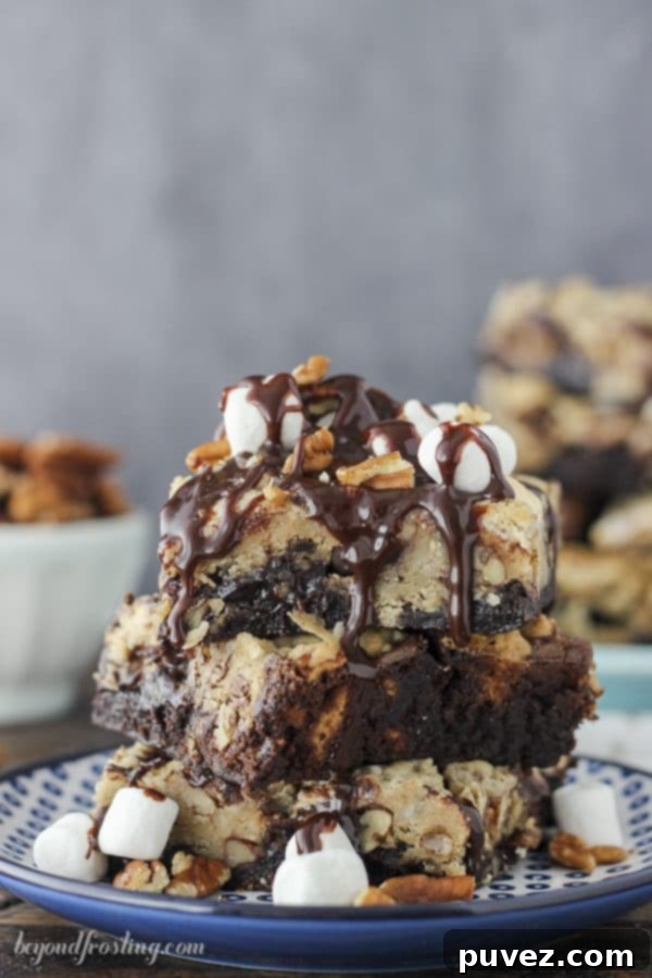 Indulge in Gooey Mississippi Mud Pie Brookies, featuring rich layers of fudgy chocolate brownie and chewy chocolate chip cookies, packed with crunchy pecans and sweet mini marshmallows for the ultimate dessert experience. A perfect shot highlighting the delicious layers.