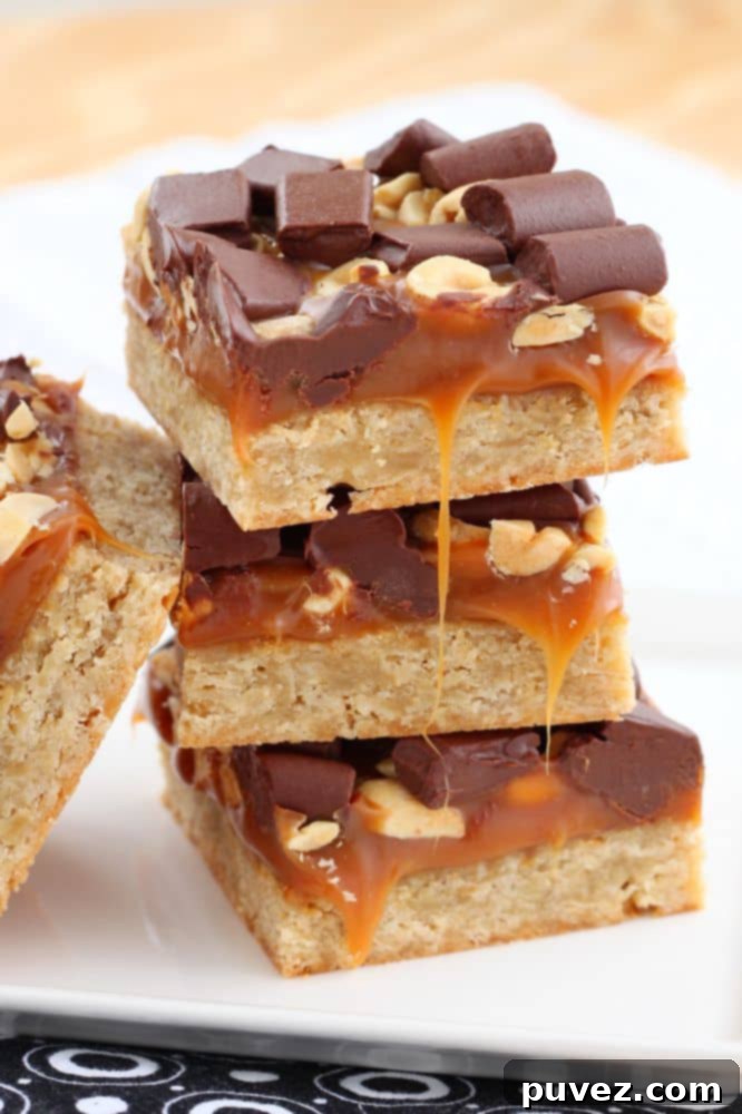 Close-up of Salty Caramel Chocolate Bars showcasing the distinct layers of crust, caramel, and chocolate-peanut topping.