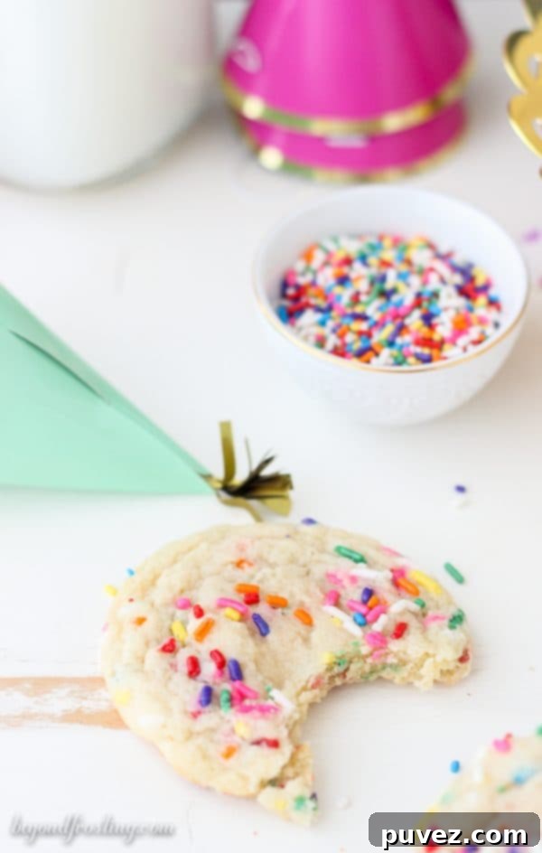 A plate full of freshly baked sprinkle sugar cookies, showing off their generous sprinkle coating.