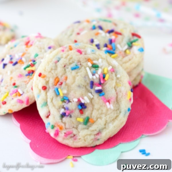 A stack of soft and chewy sprinkle sugar cookies, demonstrating their perfect texture and vibrant sprinkles.