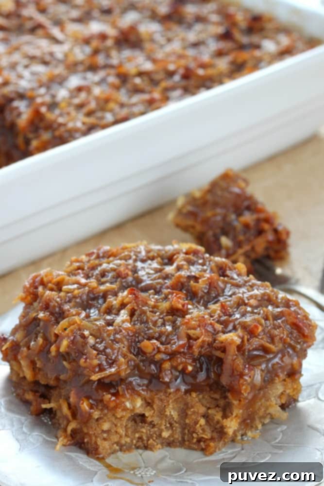 Close-up of a slice of Old-Fashioned Caramel Coconut Pecan Oatmeal Cake with a spoon