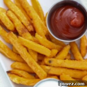 Sweet potato fries plated with ketchup and yogurt dip.