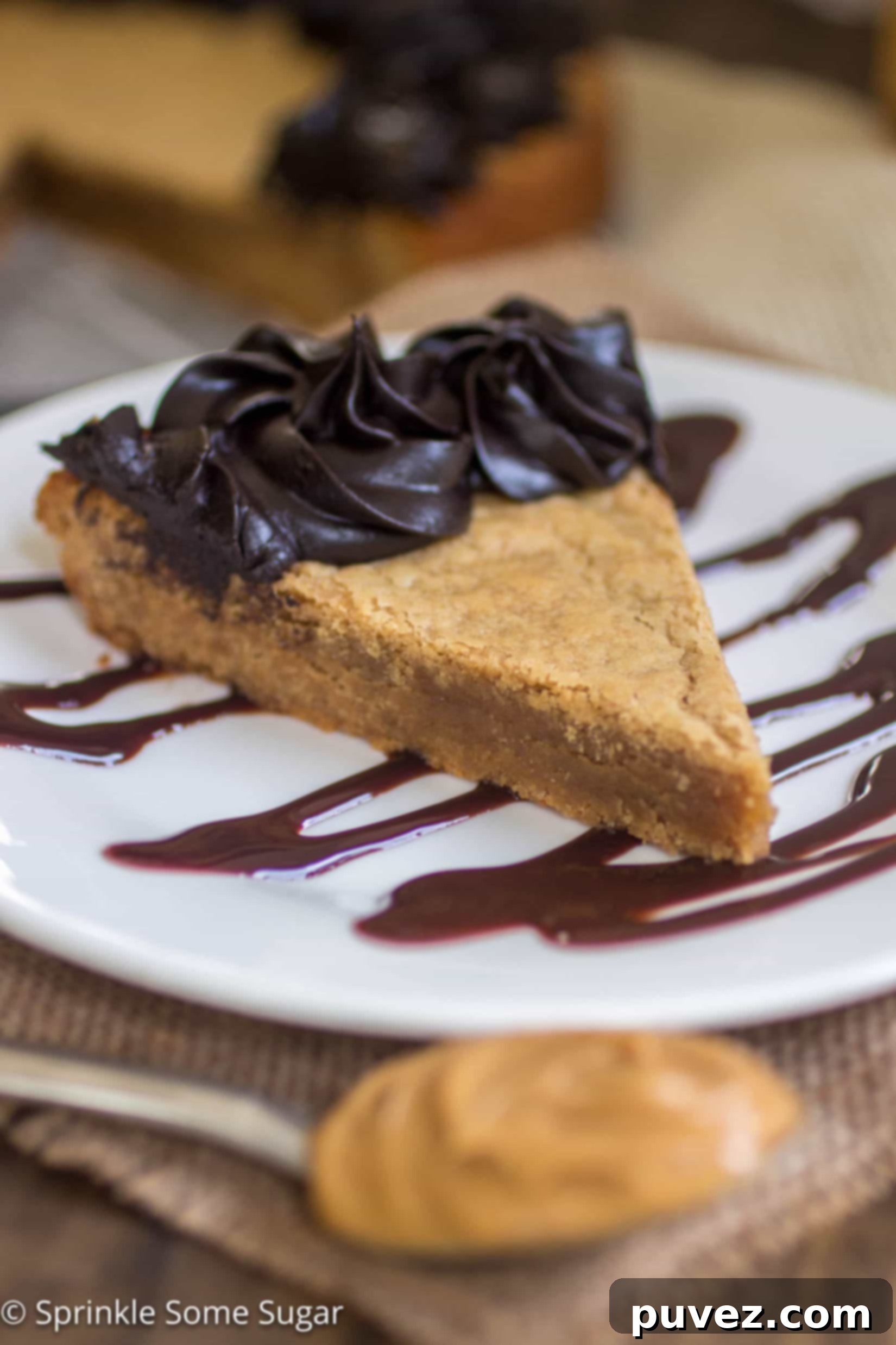 Peanut Butter Cookie Cake - A thick, chewy peanut butter cookie cake topped with a creamy dark chocolate frosting, garnished with Reese's cups.