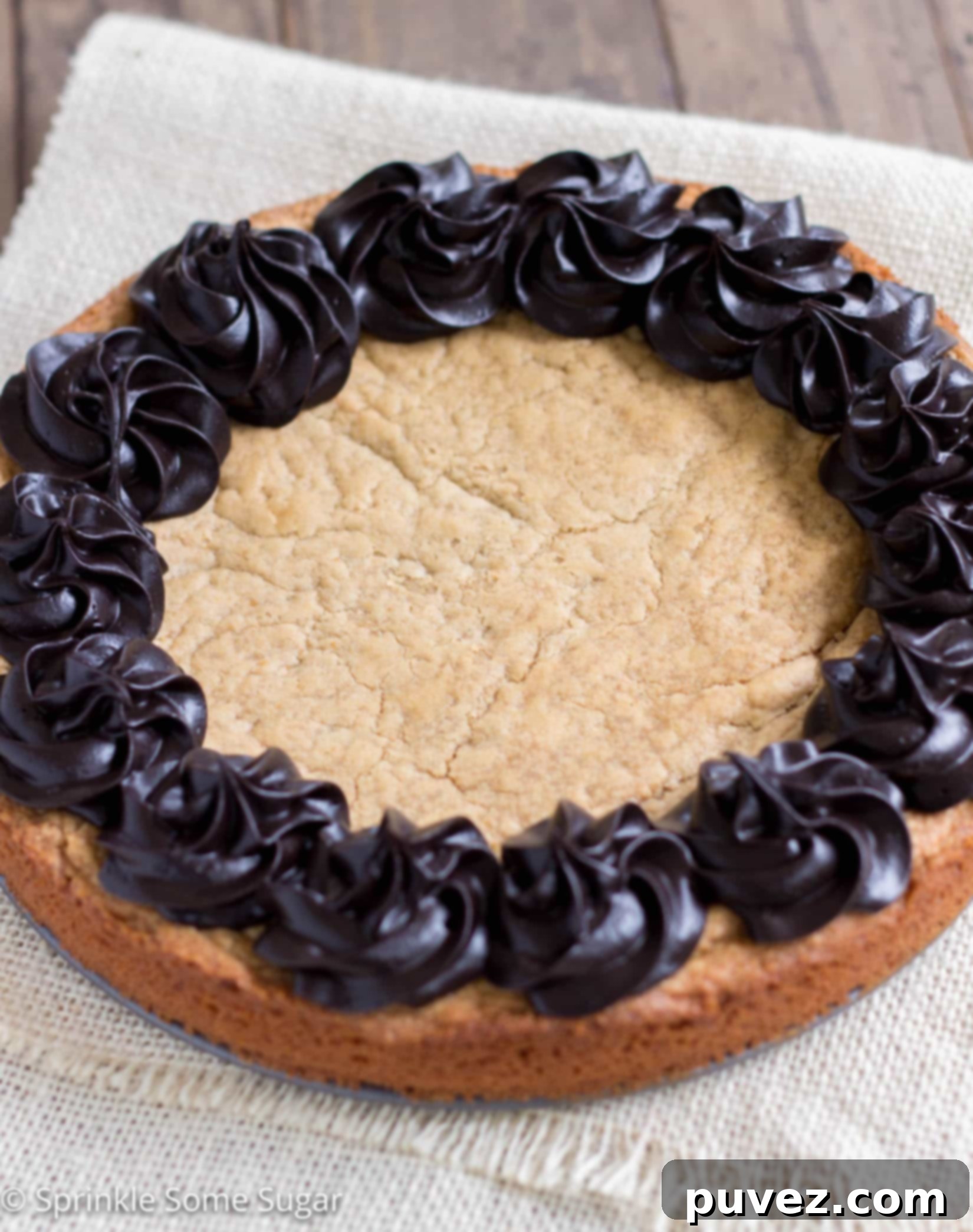 Close-up of a slice of Peanut Butter Cookie Cake showing its thick, chewy texture and rich dark chocolate frosting.