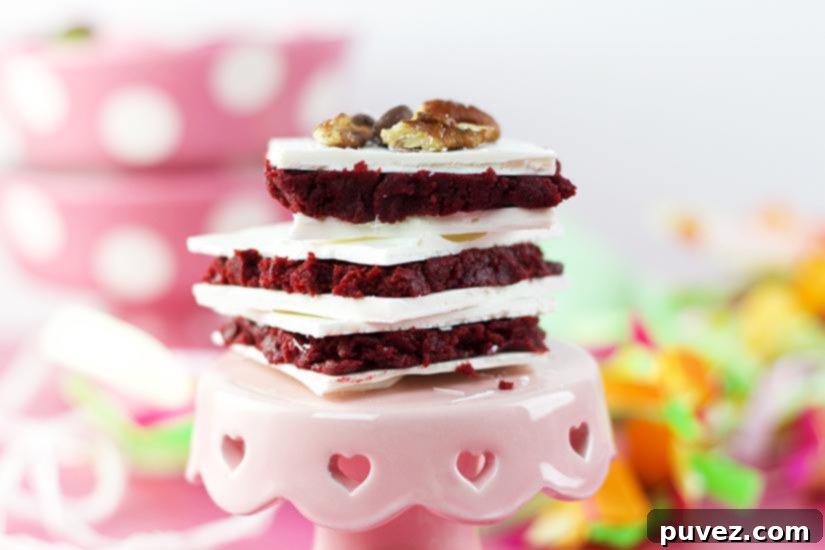 The vibrant red velvet cake and cream cheese mixture, layered perfectly between two coats of white melting candy, forming Red Velvet Truffle Bars.