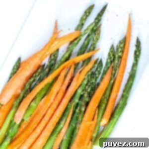 Quick and Easy Roasted Asparagus and Carrots 5 Top view of roasted carrots and asparagus on a white serving platter, ready to be enjoyed.