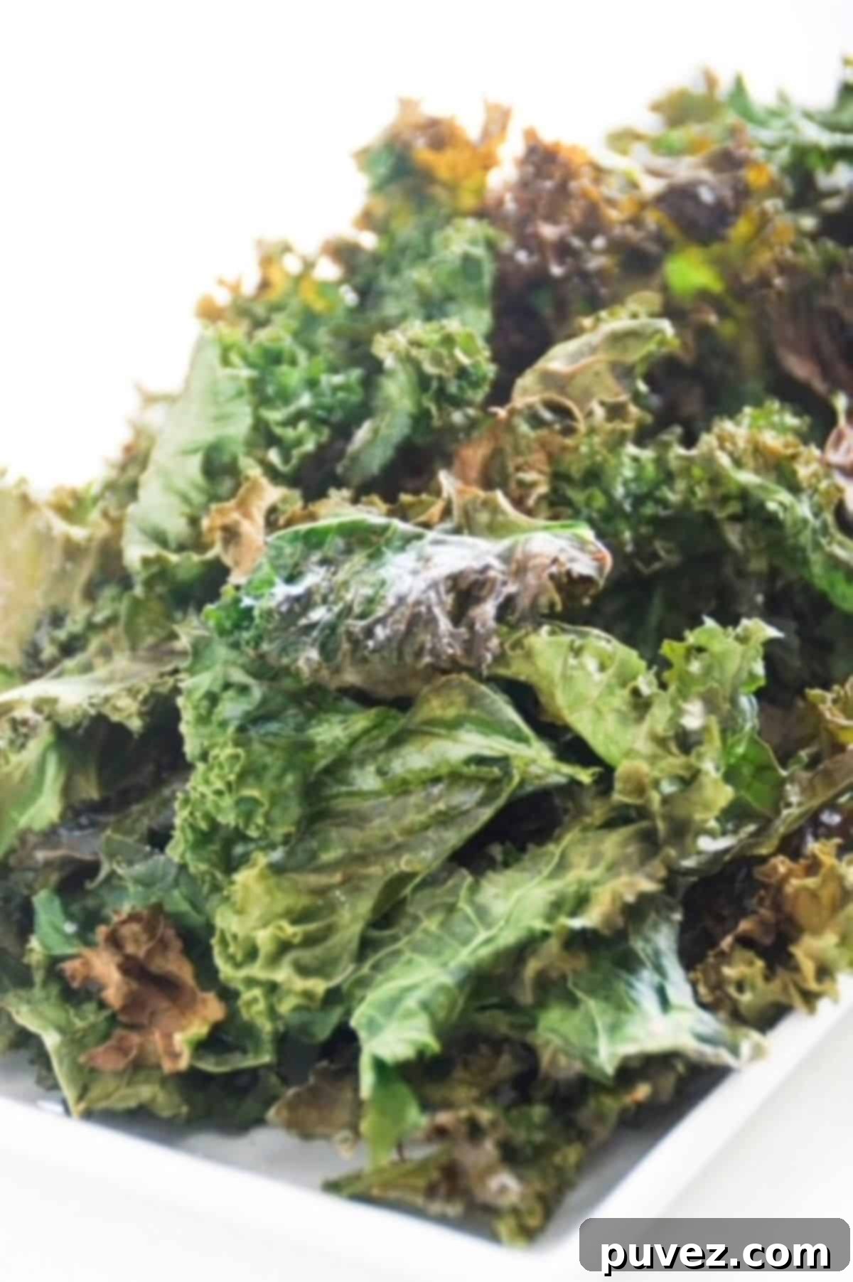 Kale chips on a white rectangular plate.