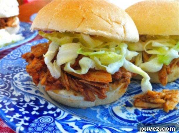 Platter of Lean & Mean Pulled-Pork BBQ with a side of coleslaw, ready to serve in buns.