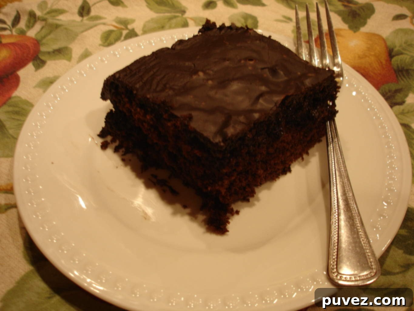 Slice of moist Coca Cola Cake with a rich chocolate frosting