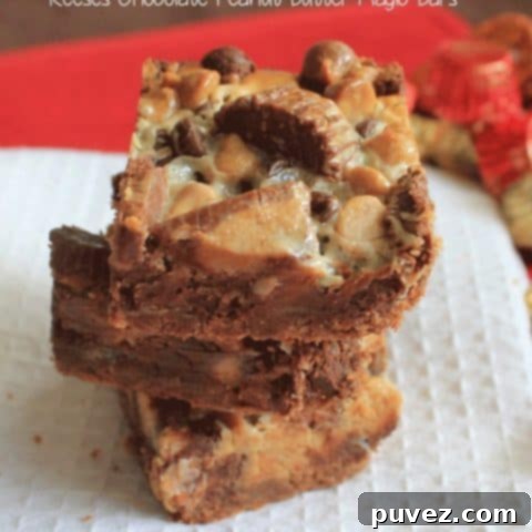 Reese's Chocolate Peanut Butter Magic Bars, showing distinct layers of chocolate and peanut butter, garnished with candy pieces.