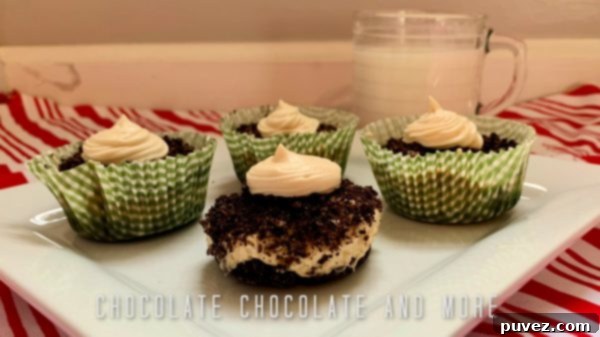 One unwrapped and three wrapped peanut butter pie cups sitting on a white square plate and a clear mug filled with milk on a red and white striped cloth and a layered gray and white background. A perfect frozen dessert.