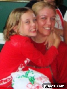 Grace Hayes and Joan Hayes hugging affectionately in the kitchen, a heartwarming mother-daughter moment.