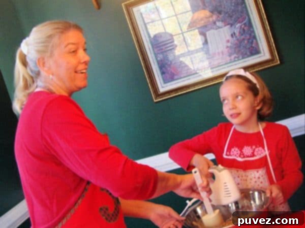 Joan Hayes and Grace Hayes mixing ingredients together in a bowl, sharing a fun baking moment.