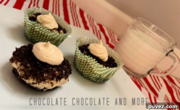 One unwrapped peanut butter pie cup and two wrapped peanut butter pie cups sitting on a square white plate and a clear mug filled with milk on a red and white striped cloth and gray and white background, ready to be enjoyed.