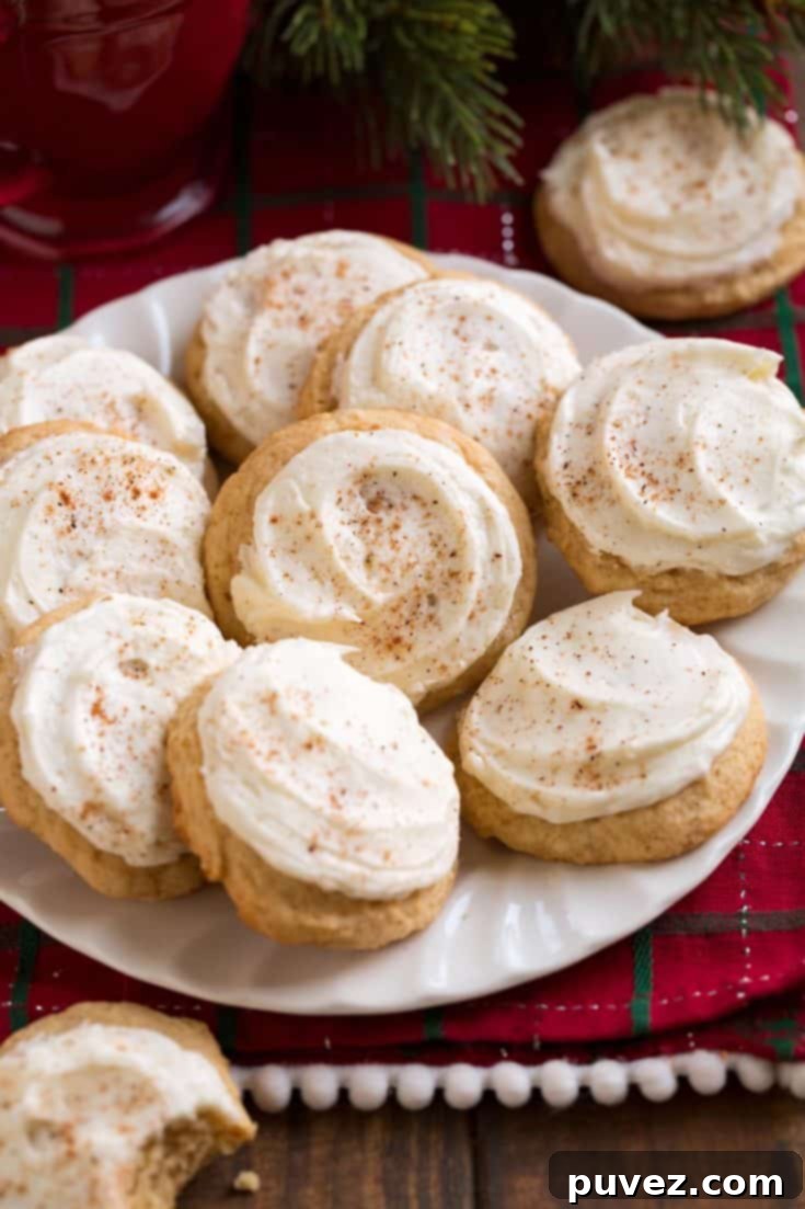 Soft, melt-in-your-mouth eggnog cookies dusted with powdered sugar, arranged on a cooling rack.