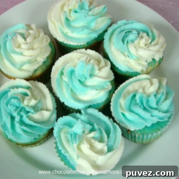 Two Jello Swirl Cupcakes, one frosted with pink and the other with orange Jello buttercream, showcasing the colorful cake swirl.