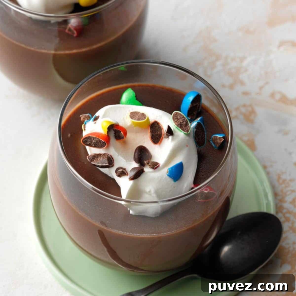 Rich and creamy Homemade Chocolate Pudding in a glass serving dish, topped with whipped cream and chocolate shavings.