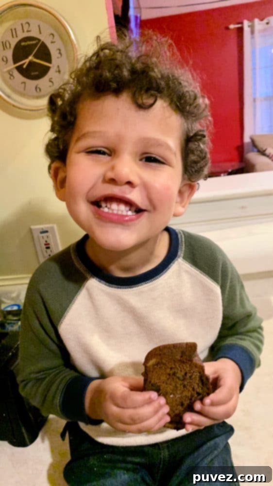 Moist Banana Nut Bread 2 Young Edward, my nephew, happily holds a slice of homemade banana nut bread with a bright smile, giving it his enthusiastic approval.