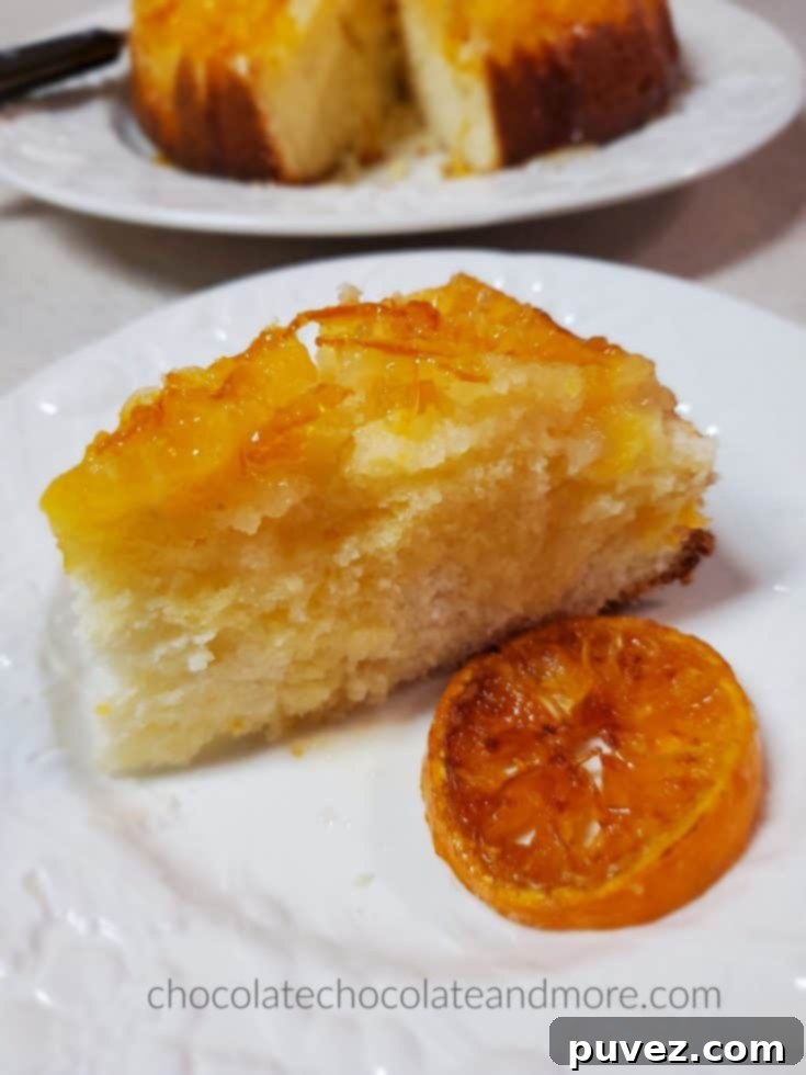 a slice of mandarin upside down cake on a plate with a slice of candied orange