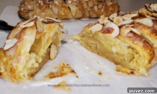 Almond puff pastry cooling on a wire rack with a drizzle of glaze.