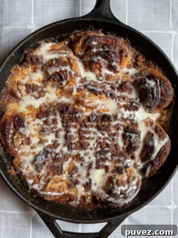 A close-up shot of the Cinnamon Roll Dessert Casserole, glistening with a fresh drizzle of icing, ready to be enjoyed.