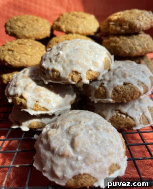 Pumpkin Spice Oatmeal Cookies with a shiny, sweet glaze stacked on a cooling rack.