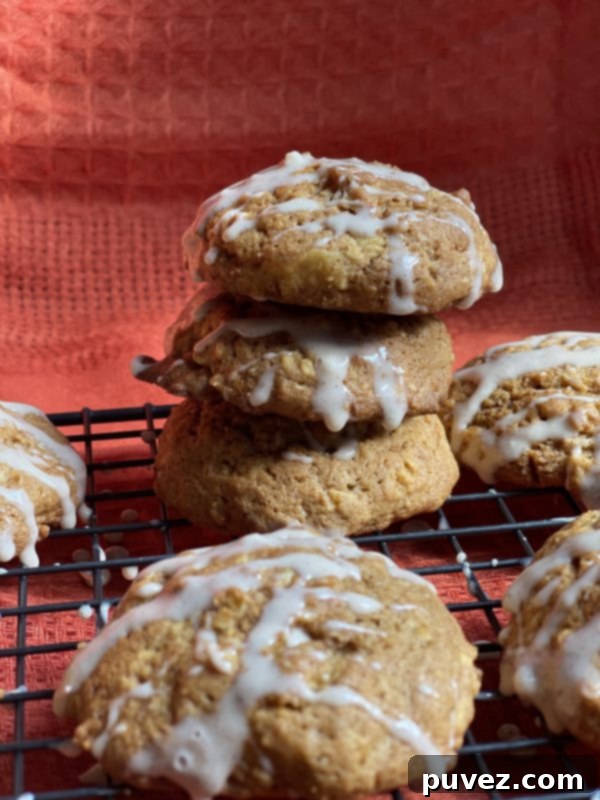 Three glazed Pumpkin Spice Oatmeal Cookies stacked, showcasing the sweet glaze and chewy texture.