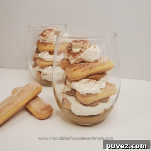 two clear glasses with layers of tiramisu and lady finger cookies