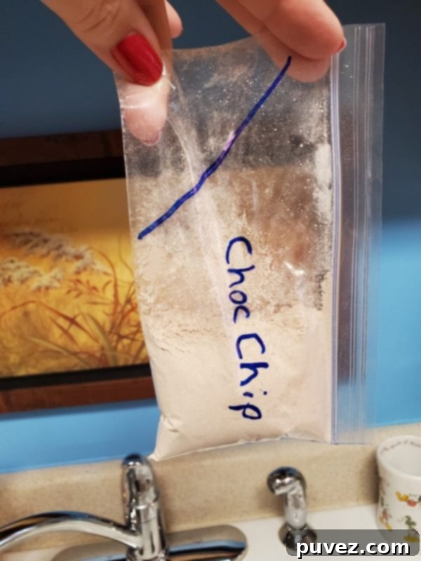 Quick And Easy 1 Minute Mug Cake 2 A person pouring a dry mug cake mix from a prepared baggie into a white mug.