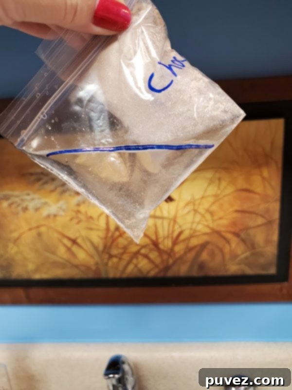 Quick And Easy 1 Minute Mug Cake 3 A close-up of a mug cake mix with various candy pieces and chocolate chips, ready to be stirred.