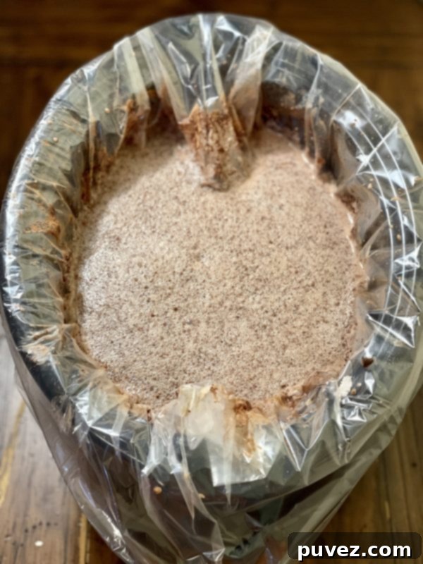 The ingredients for the absolute best crockpot hot chocolate combined in the slow cooker, ready to cook.