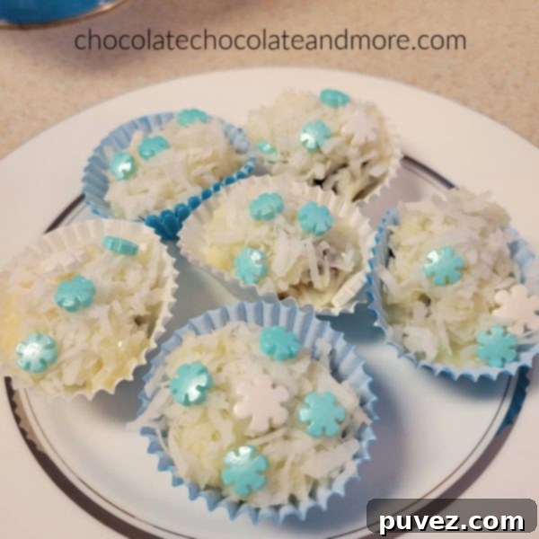 A close-up shot of a plate brimming with freshly made coconut date snowballs, sprinkled with delicate blue and white decorations.