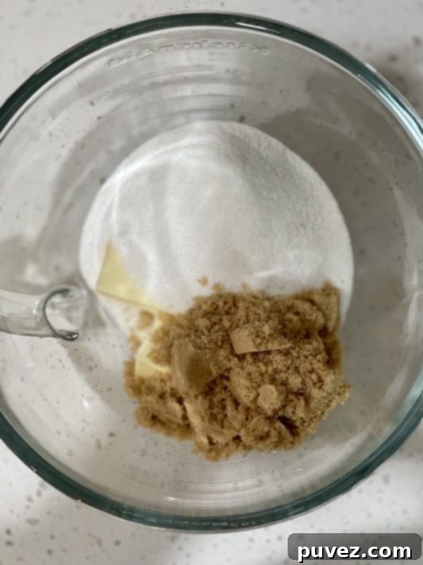 Butter, brown sugar and granulated sugar in a glass bowl.