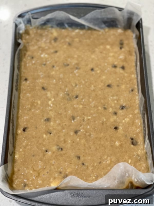 Smooth banana bread cake batter poured into a 9x13 inch baking pan, ready for the final touches