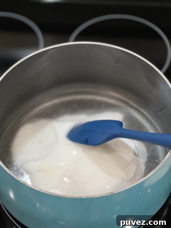 Granulated sugar and light corn syrup being combined in a large saucepan