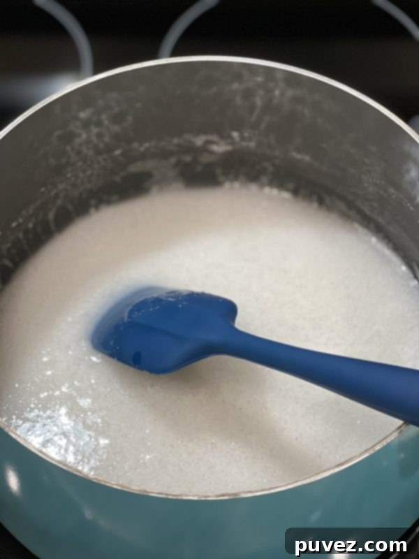 Sugar and light corn syrup mixture gently boiling in a saucepan