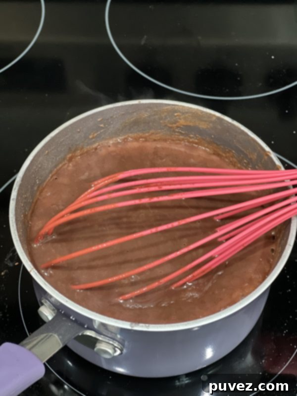 Rich, velvety chocolate gravy simmering in a small saucepan, freshly thickened